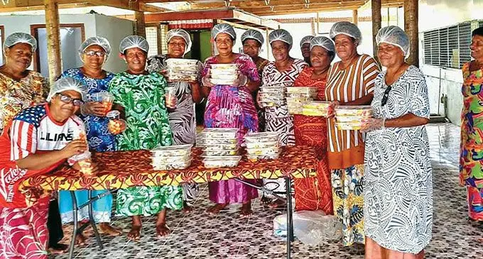 Nananu women preparing food packs for FIJI Water employees.