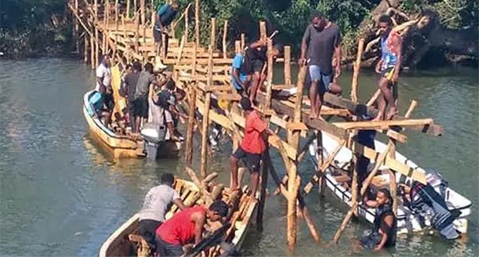Villagers rebuild a wooden bridge at Bua Lomanikoro in Bua, Vanua Levu on August 2, 2021.