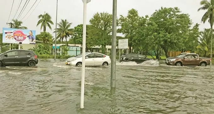 Vehicles drive through the flooded junction at Laucala Bay Road and Queen Elizabeth Drive in Suva on March 25, 2021.  Photo: Wati Talebula-Nuku