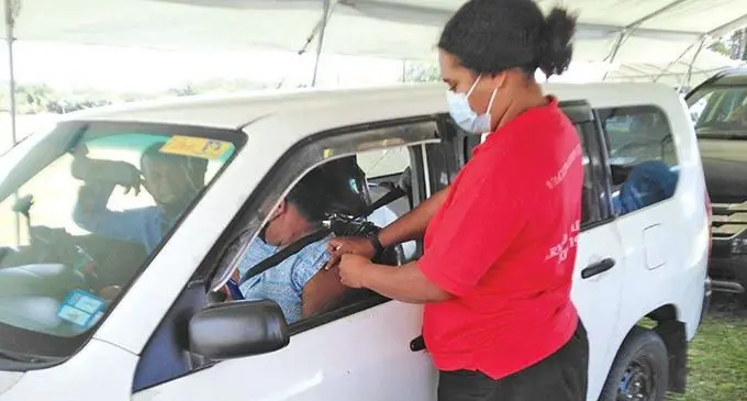 Nurse Kinisimere Drauna administering the COVID 19 vaccine to a couple at the drive-through at the Subrail Park in Labasa on August 7, 2021. 