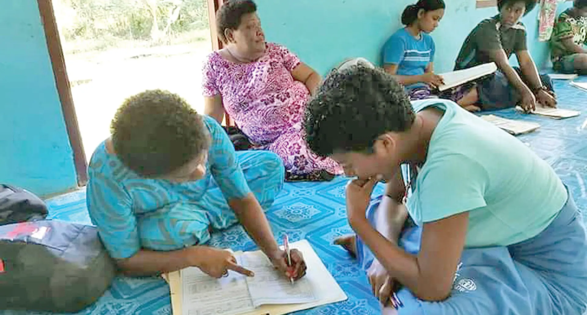 A Holy Cross College teacher attends to one of the many students at Dakuniba Village, Vanua Levu, on September 15, 2021.  