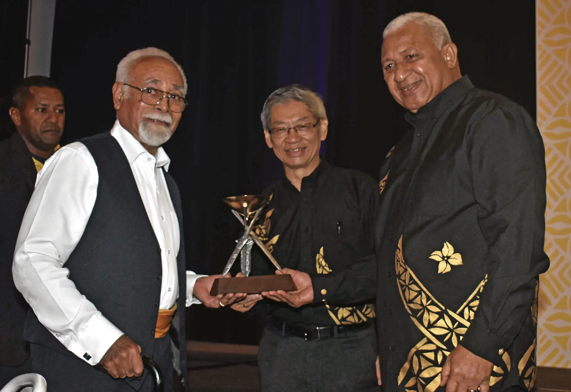 Radike Qereqeretabua receives the award on behalf of late Patrick 'Paddy' Doyle, FHTA Chairman Dixon Seeto, and Prime Minister Voreqe Bainimarama during the 2018 ANZ FETA at the Sofitel Fiji Resort and Spa on Denarau last night. Photo: WAISEA NASOKIA