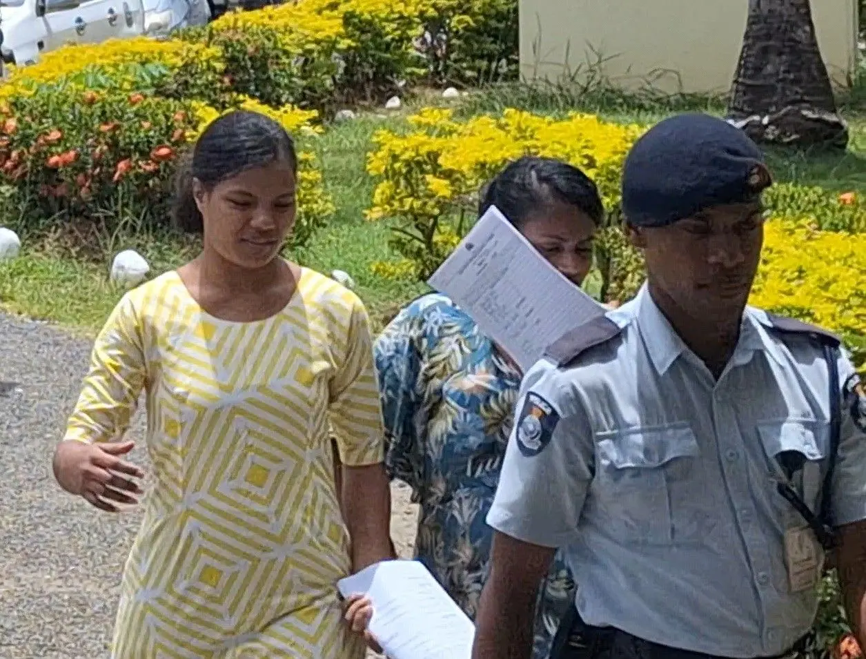  Savaira Loco and Famisa Imrana following a police officer outside the Nadi Magistrate Court. 
