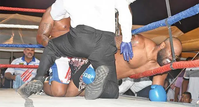 Heavyweight boxer Semi Dauloloma grimaces in pain after he was punched by James Singh on the canvas as referee Fatu Tuimanono (back to camera) tries to separate the two boxers at Lawaqa  Park, Sigatoka, on August 31, 2024. Insets: Ring officials step in to stop the brawl.  Photos: Waisea Nasokia