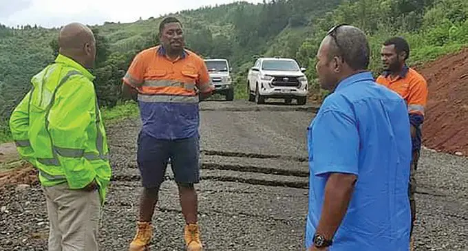 Ministry of Infrastructure staff members inspect road damage in the Western Division.  Photo: National Disaster Management Office