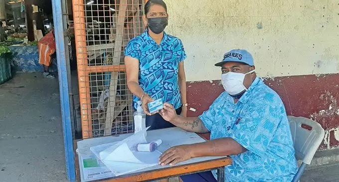 Lautoka City Council staff checks Meena Devi’s vaccination card.