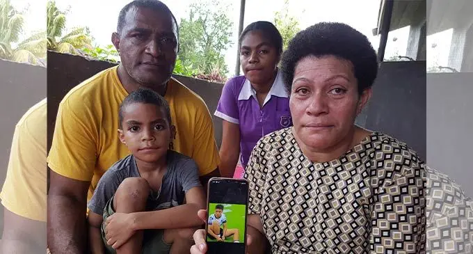 Torika Koroidrekelevu shows a photo of her late daughter, Monika Nokata Koroidrekelevu while her husband, Josefa, daughter, Lavenia and youngest son, Marika  outside their home at Volivoli Village in Sigatoka on August 8, 2022. Photo: Nicolette Chambers