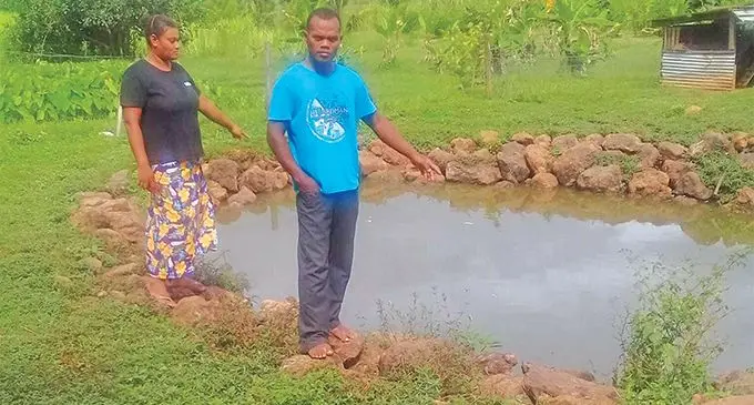 Tomasi Fabiano and his wife, Vuli Talei, at the pond where their son allegedly drowned on March 20, 2019.