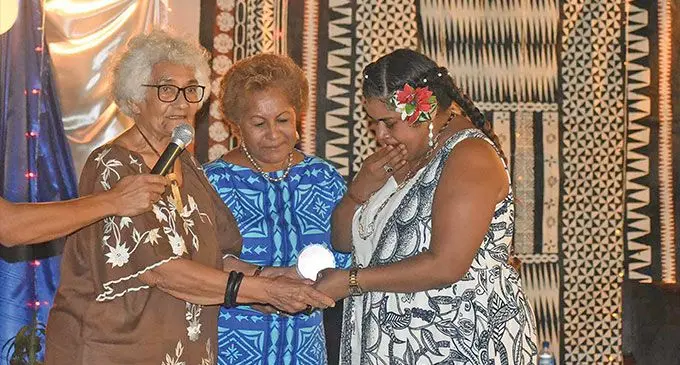 From left: Lorine Tevi (former FCOSS volunteer), and Emele Duituturaga (former director PIANGO) presenting the Bula Re Award for Veteran Community Volunteer to Asela Naisara’s daughter, Sophy Radrodro