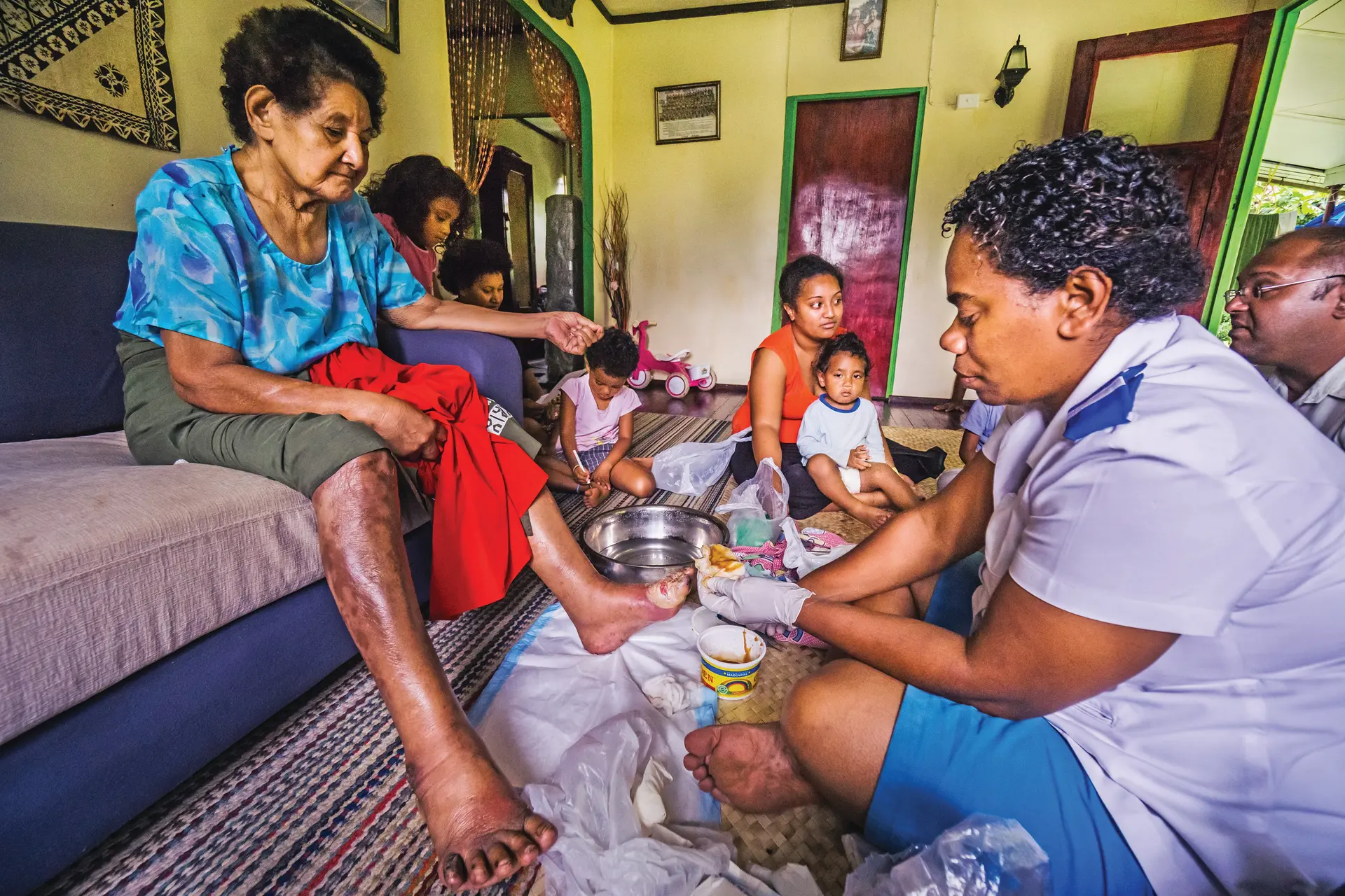 A nurse attends to a woman living with diabetes during a home visit.